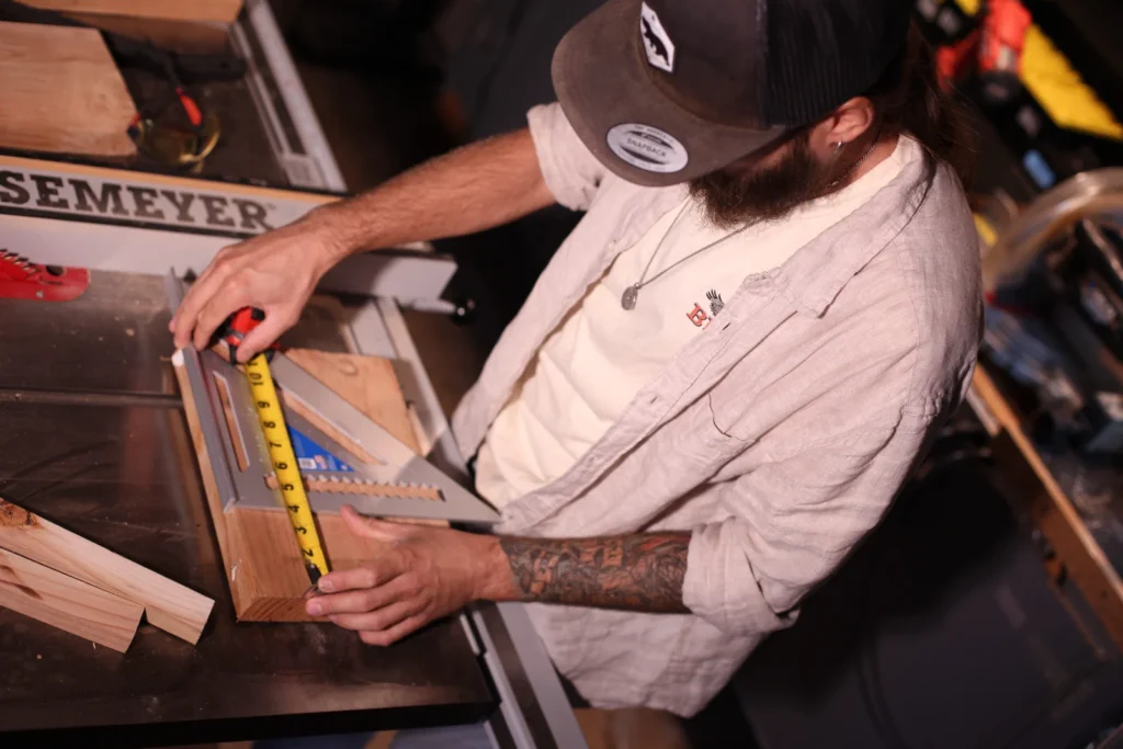 Alex checking a wooden piece with a tape measure and square