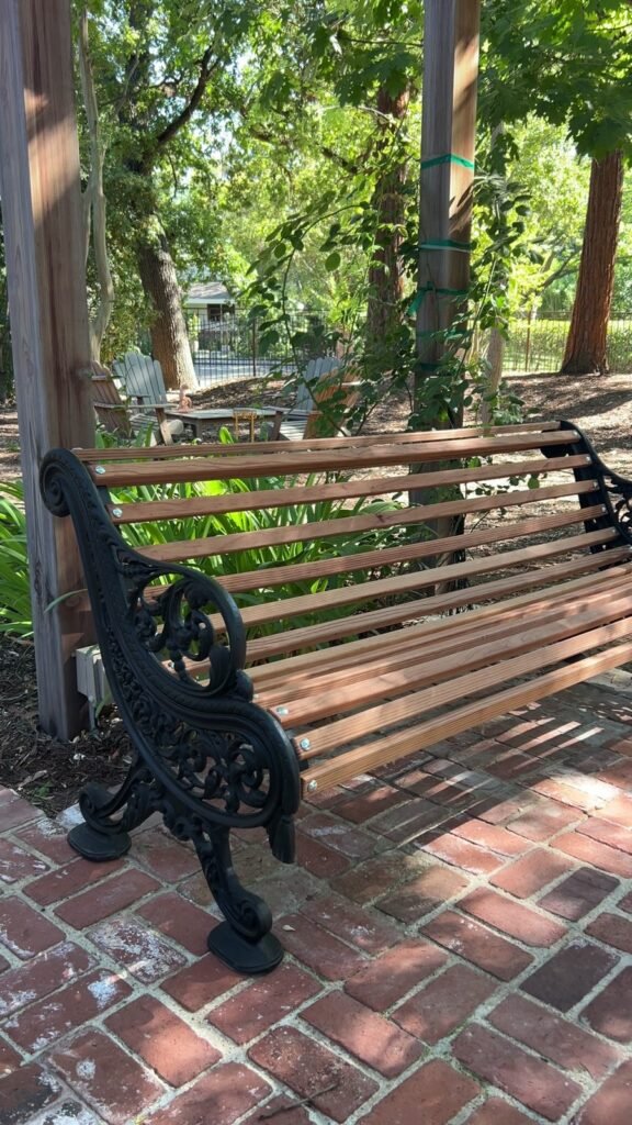 Restored garden bench with new wood slats and the original metal frame